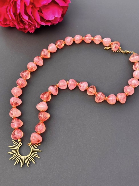 Collier fantaisie composé de perles naturelle de couleurs corail et réhaussé par un pendentif solaire en acier inoxydable pour un effet bohème chic et raffiné 