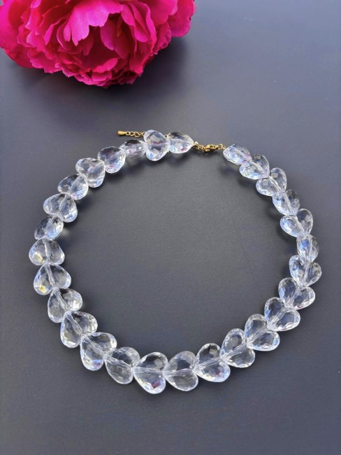 Collier fantaisie composé de perles de verre blanches en forme de coeur, se portant en ras de cou pour un style bohème chic et raffiné