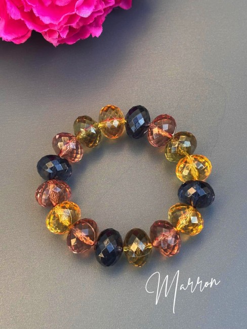 Bracelet bohème chic composé de grosses perles colorées facettées multi-couleurs marron, vert kaki, jaune, bleu évoquant le raffinement des palais italiens, sublimé par de délicates influences orientales.