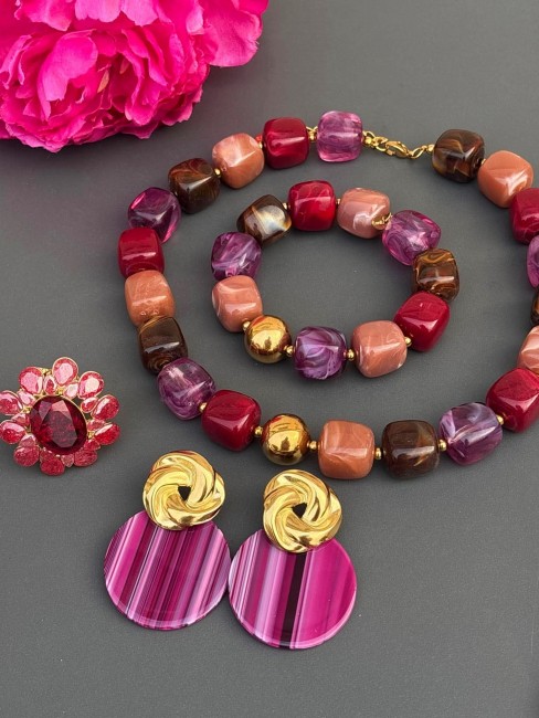 BYZANCE - Parure Collier et bracelet aux perles de résines aux teintes beiges marronées violet rose et doré accompagnés des boucles MONA et bague sofia Parure BYZANCE composée d'un Collier et d'un bracelet aux perles de résines aux teintes beiges marronées violet rose et doré pour un style bohème choc oriental nomade accompagné de la bague sofia en strass grenat et les boucles mona violettes