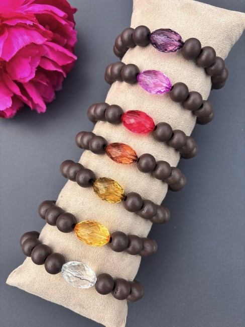 Bracelet fantaisie composé de perles de bois d'un brun mat et d'une perle de verre ovale aux couleur éclatante  pour un contraste à la fois chaleureux et lumineux.