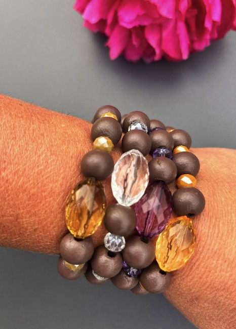 Bracelet fantaisie composé de perles de bois d'un brun mat, d'une perle de verre ovale aux couleur éclatante; le tout réhaussé par quatre perles de bohèmes pour un contraste à la fois chaleureux et lumineux.