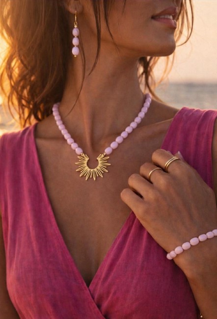 Ensemble composé d'un collier, de boucles d'oreilles et d'un bracelet de perles naturelles de couleurs parme pour un style hypnotisant coloré et bohème chic; à noter que le collier est réhaussé d'un pendentif en acier inoxydable en forme de soleil