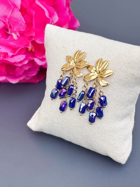 Boucles d'oreilles fantaisie composées d'une fleur en acier inoxydables et de perles naturelles pendantes en cascade en sodalite bleu, ce qui donne un effet bohème chic et solaire