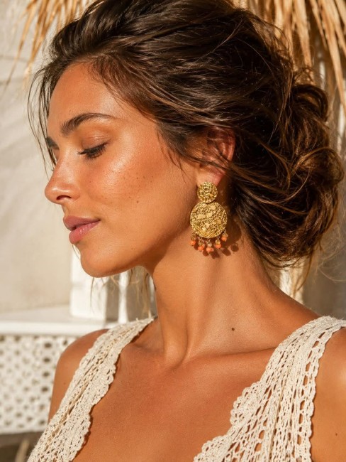 MILOS - Boucles d'oreilles martelées et perles naturelles orange en cornaline Inspirées des paysages lumineux de la Méditerranée, les boucles MILOS séduisent par leurs disques martelés aux reflets dorés et leurs délicates perles naturelles facettées orange en cornaline