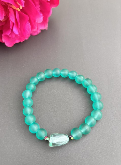 Bracelet fantaisie composé de perles givrées verre d'eau, d'une perle centrale en résine et de 2 perles types swarovski