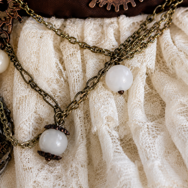 Détail des opales blanches et des chaînettes en laiton disposées sur la dentelle de Calais ivoire du tour de cou haute couture Les Secrets de l’Horlogère.