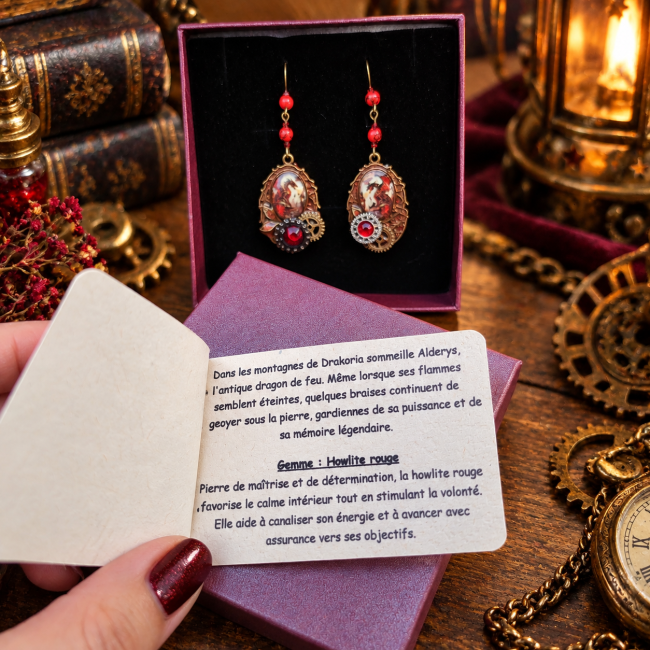 Les Braises d’Alderys – Écrin, Dragon et Howlite Rouge Présentation des Braises d’Alderys dans leur écrin avec leur carte de création, autour de l’univers du dragon, de la howlite rouge et de l’esthétique victorienne steampunk.