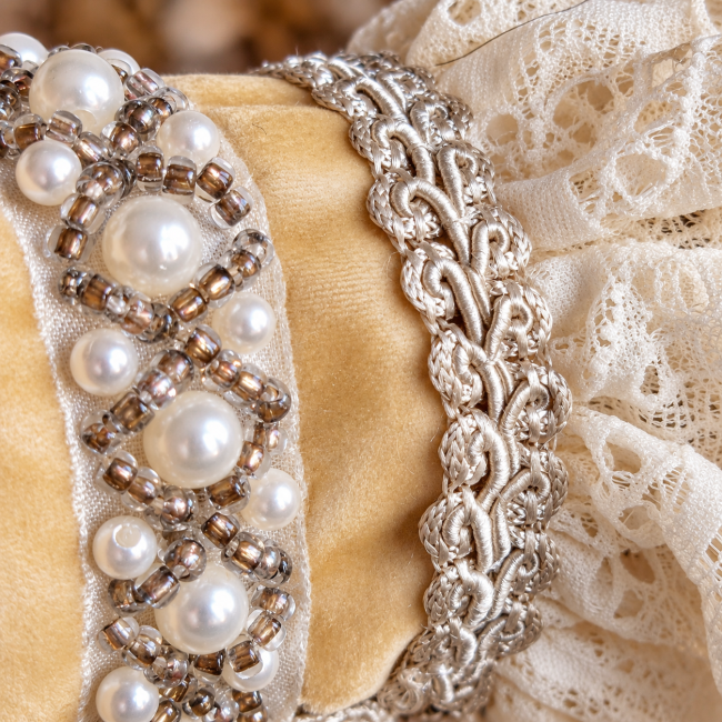 Perles nacrées et ornements argentés soulignent les finitions raffinées de ces manchettes baroques. La précision du montage et les détails cousus à la main expriment l’esprit haute couture de cette création artisanale.
