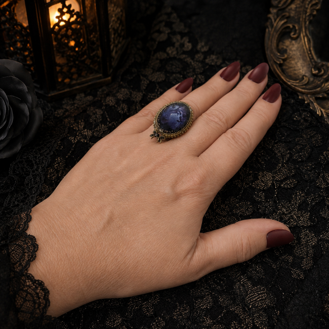La création artisanale Celle qui demeure portée avec élégance par une femme aux cheveux roux, révélant toute la présence de cette bague gothique aux accents mystérieux.
