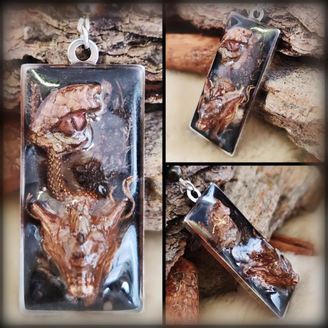 Détail du pendentif Le Drac – Fantaisies d’A. Zoom sur le pendentif du collier Le Drac : personnage dragon en 3D, émail coloré transparent et médaillon sculpté. Travail artisanal unique par Fantaisies d’A.