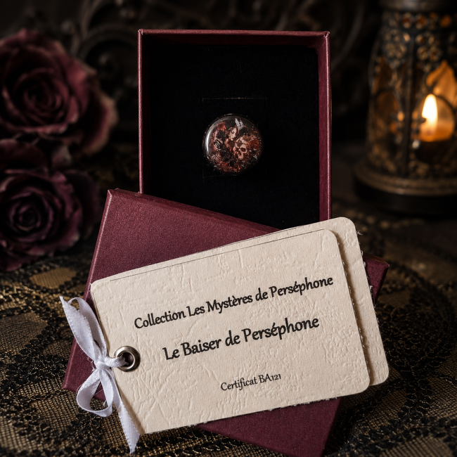 Bague gothique Le Baiser de Perséphone – Écrin | Les Fantaisies d’A Le Baiser de Perséphone, bague gothique pour femme de la collection Les Mystères de Perséphone, présentée dans son écrin avec sa carte d’identification.