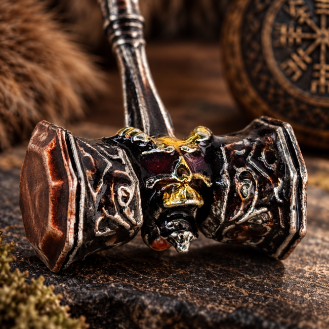 Gros plan sur la tête de démon qui orne le maillet antique, mettant en valeur les reliefs, les détails des motifs et l’émaillage artisanal réalisé à la main.