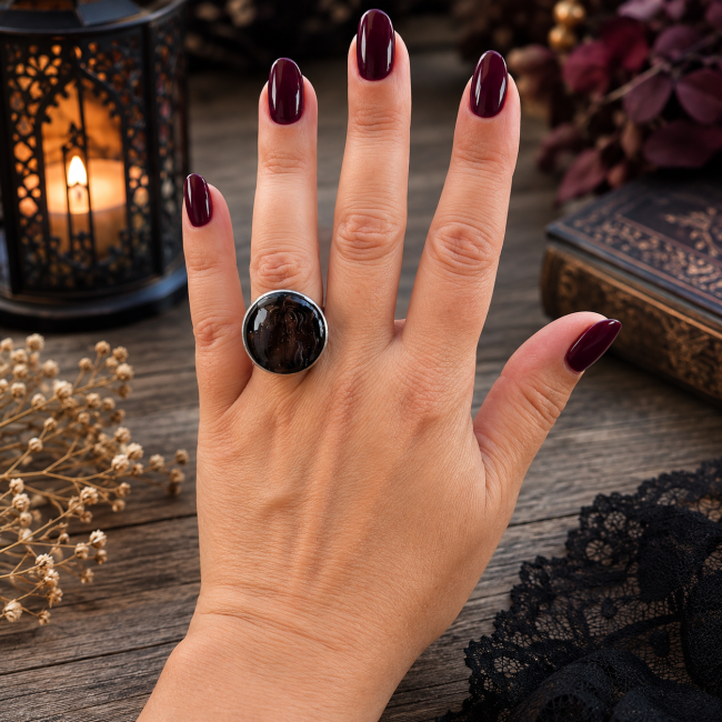 Gros plan sur le cabochon bombé de la bague Le Gouffre du Drac, révélant son décor dragonique en relief 3D réalisé artisanalement sous l’émail.