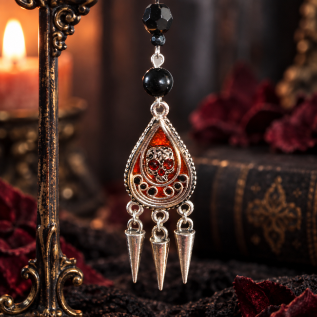 L’Épine d’Obsidienne – Détail du bijou gothique artisanal Détail d’une boucle d’oreille L’Épine d’Obsidienne avec perles noires, médaillon goutte émaillé et trois pointes