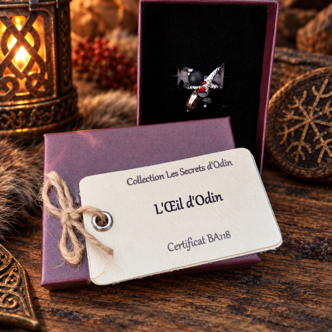 Bague viking L’Œil d’Odin en écrin – Les Secrets d’Odin L’Œil d’Odin présenté dans son écrin avec sa carte d’identification, une présentation soignée et prête à offrir pour cette création artisanale d’inspiration viking.