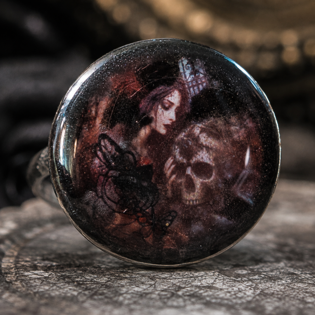 Cabochon bague Le Baiser de Perséphone – Détail du bijou Gros plan sur le cabochon du Baiser de Perséphone, révélant son décor sombre aux nuances brun rouge, noir et pourpre ainsi que ses motifs évocateurs.
