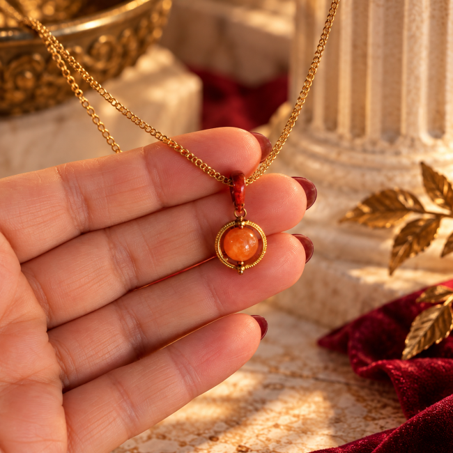 Détail du collier Luna avec perle en andésine véritable orange et médaillon rouge réversible