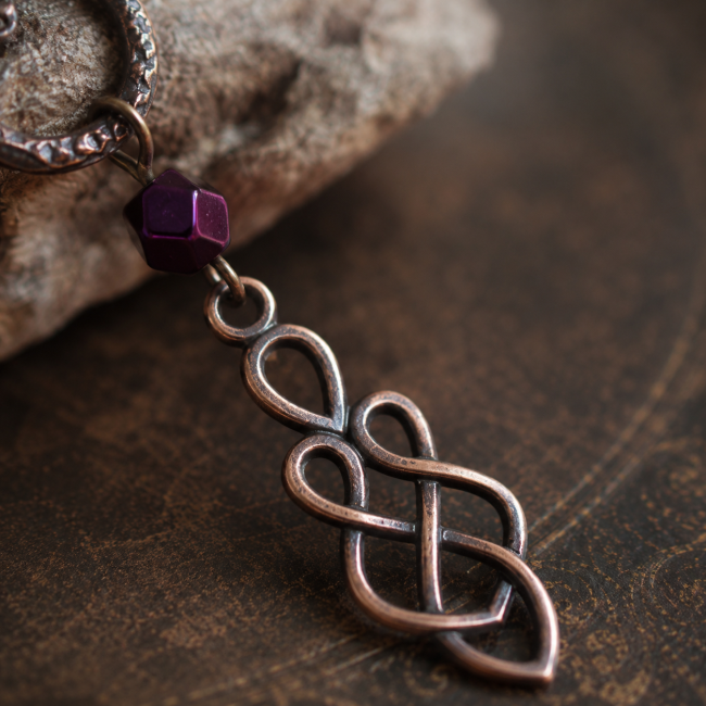 Détail de l'entrelacs celtique – Le Lien de Brigid Gros plan sur le pendentif en nœud celtique et la perle d'hématite des boucles d'oreilles Le Lien de Brigid.