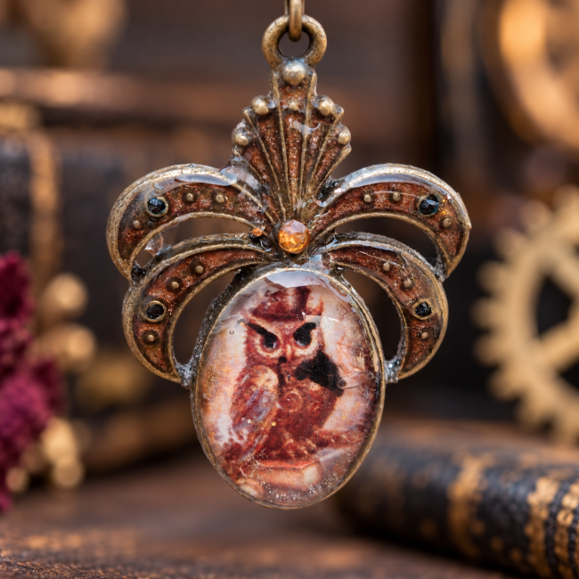 Cabochon des boucles d’oreilles Les Yeux de la Lune Rousse Gros plan sur le cabochon central révélant la chouette aux teintes rousses, enchâssée dans une monture ornée aux accents cuivrés.