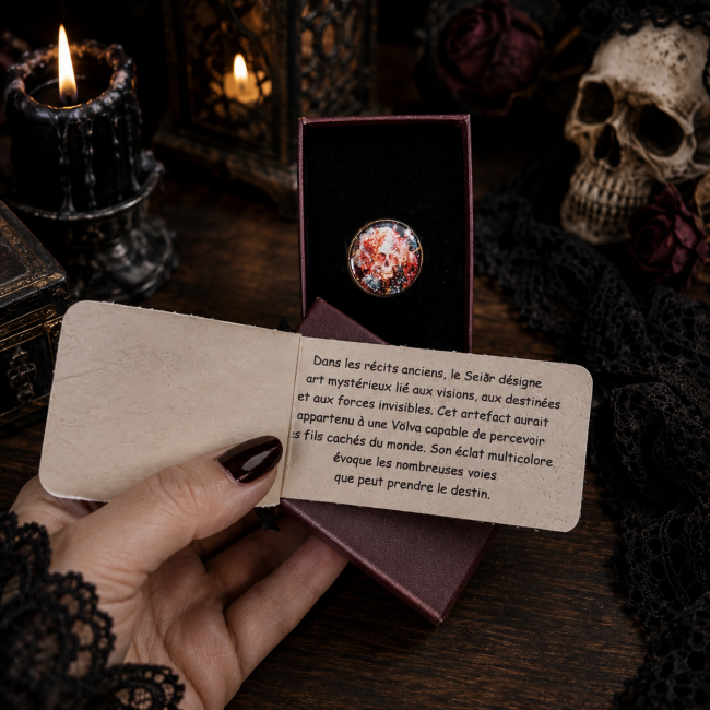 Légende de L’Artefact du Seidr, création artisanale de la collection Hrafnseiðr. Découvrez l’univers mystérieux du Seiðr, des visions et des forces invisibles à travers cette bague gothique ornée d’un cabochon aux couleurs rouge, bleu et scintillantes.
