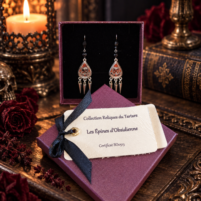 L’Épine d’Obsidienne dans son écrin – Création gothique artisanale Boucles d’oreilles gothiques L’Épine d’Obsidienne présentées dans leur écrin, avec émaillage artisanal et véritables perles d’obsidienne noire