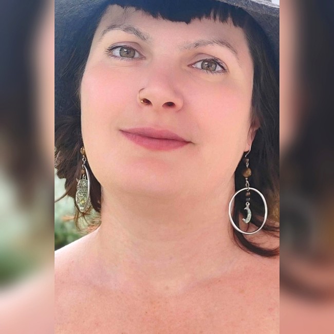 Les boucles d’oreilles Phoebé se révèlent portées, éclats d’argent et reflets dorés d’œil de tigre.