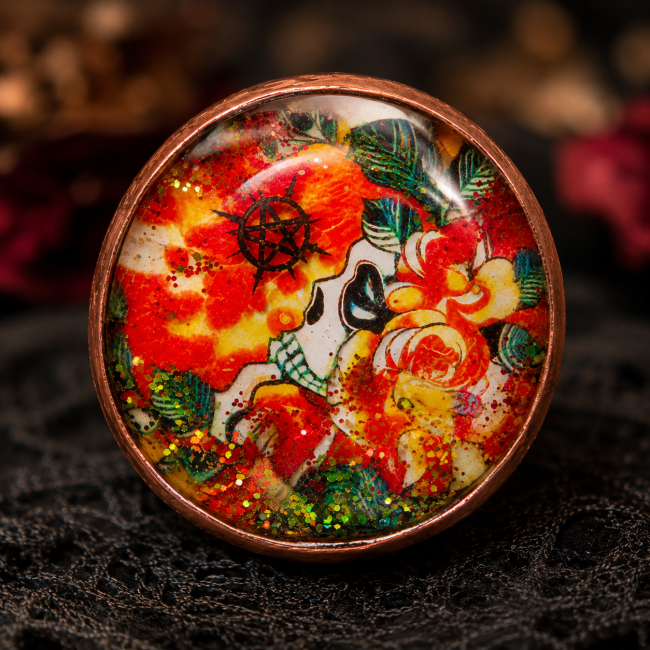 Le Crâne Écarlate – Cabochon émaillé à la main, crâne, fleurs et pentacle Cabochon de la bague Le Crâne Écarlate émaillé à la main, avec crâne, fleurs rouges et orangées, pentacle et scintillances