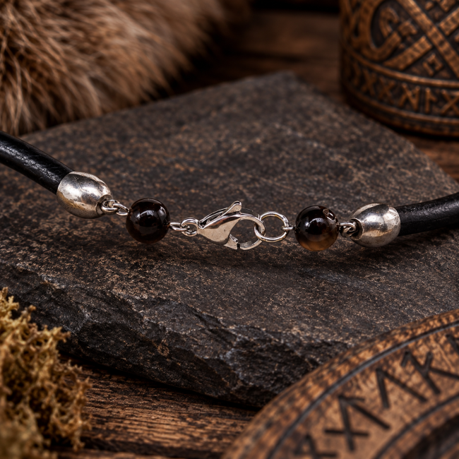 Détail du système de fermeture du collier : mousqueton, perles d’œil de tigre placées de chaque côté et embouts de cordon en acier inoxydable.