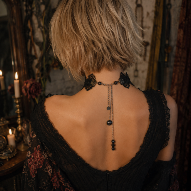 Vue arrière du tour de cou en dentelle et satin noirs Vue arrière du tour de cou artisanal révélant ses finitions en dentelle et satin noirs, sa conception textile et son élégante réalisation faite main.