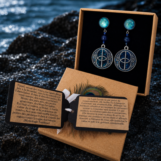 Boucles d'oreilles Njörd dans leur écrin – Coffret cadeau artisanal Présentées dans leur écrin personnalisé avec carte d'identification et carte de lithothérapie, les boucles d'oreilles Njörd offrent une expérience immersive inspirée de la mythologie nordique et de la puissance des océans.
