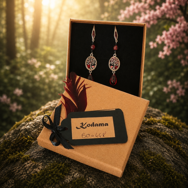 Écrin artisanal – Kodama Le Sang du Cerisier Les boucles d’oreilles Le Sang du Cerisier présentées dans leur écrin artisanal Kodoma, accompagnées de leur carte d’identification numérotée et de leur carte lithothérapie. Une présentation élégante dans une ambiance inspirée des forêts japonaises.