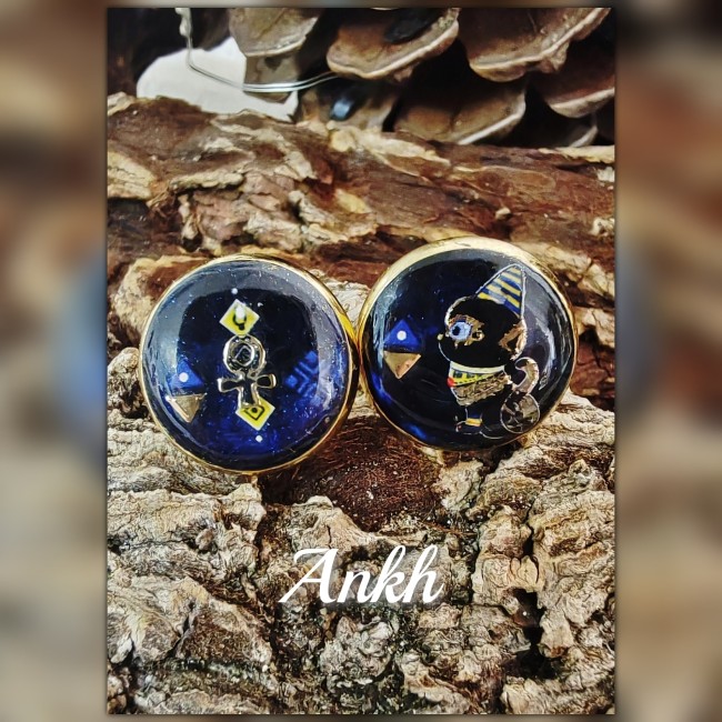 Gros plan boucles d’oreilles Ankh émaillées – Bijou égyptien artisanal | Les Fantaisies d'A Gros plan sur les clous d’oreilles Ankh artisanaux en émail bleu marine et doré – bijou égyptien unique