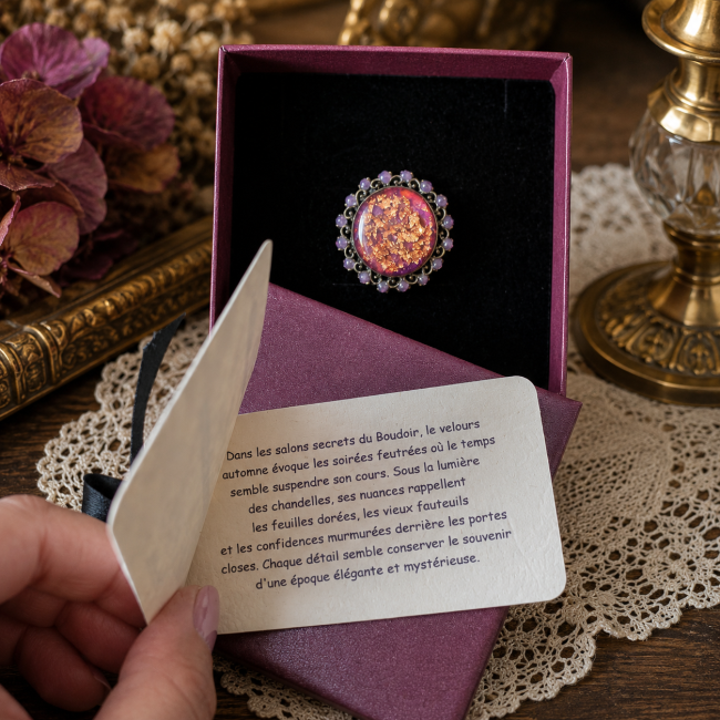 Bague victorienne artisanale en laiton, ornée d’un grand cabochon émaillé aux inclusions de feuilles de cuivre et d’un entourage violet, présentée dans son écrin de créateur.