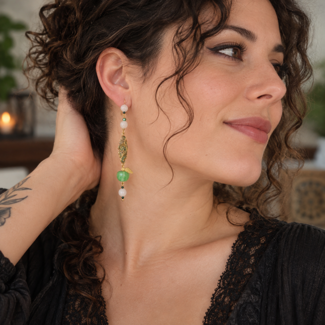 Le Jardin d’Idunn porté – Boucle d’oreille viking artisanale Boucle d’oreille Le Jardin d’Idunn portée par une jeune femme brune aux cheveux bouclés, style rock bohème.