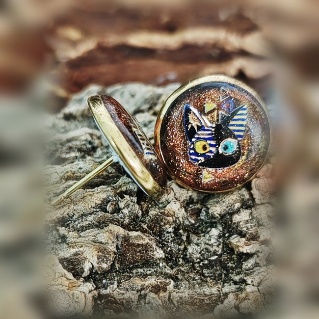 Détails clous d’oreilles Osiris – Face et profil – Artisanat égyptien | Les Fantaisies d'A Détails des boucles d’oreilles Osiris de face et de profil avec œil symbolique et tête du petit chat égyptien