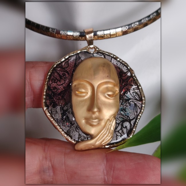 Montés sur une chaîne plate en acier inoxydable argent et doré, les colliers révèlent un pendentif circulaire irrégulier, émaillé à froid en transparence scintillante sur une délicate dentelle noire.