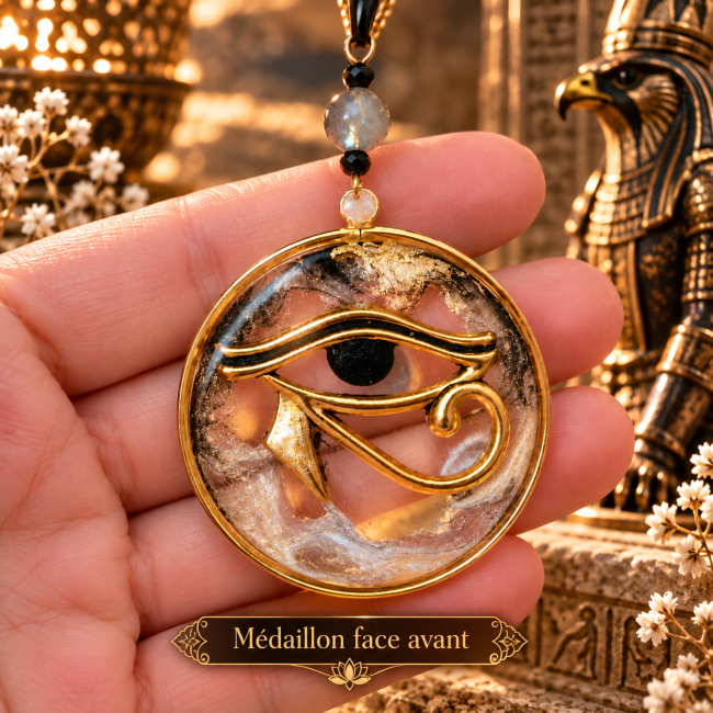 Médaillon du collier La Dualité Sacrée représentant l’Œil d’Horus, avec détails dorés et labradorite.