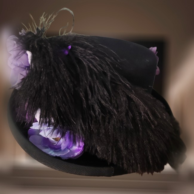 Arrière du chapeau Mina – Plumes naturelles et élégance gothique Arrière du chapeau steampunk Mina mettant en valeur un bouquet de plumes d’autruche noires TITLE