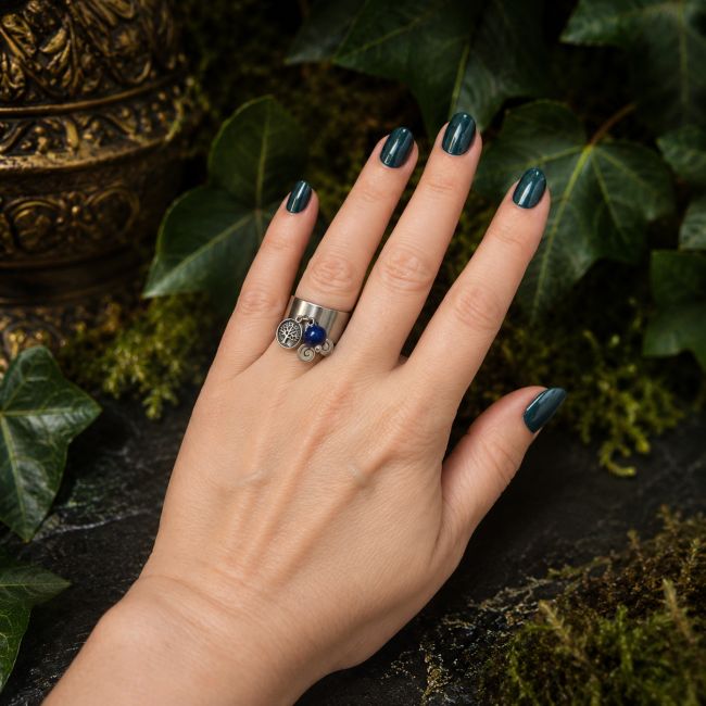 La Promesse des Immortels – Bague portée Bague La Promesse des Immortels portée par une femme, ornée d'une chrysocolle et de breloques celtiques