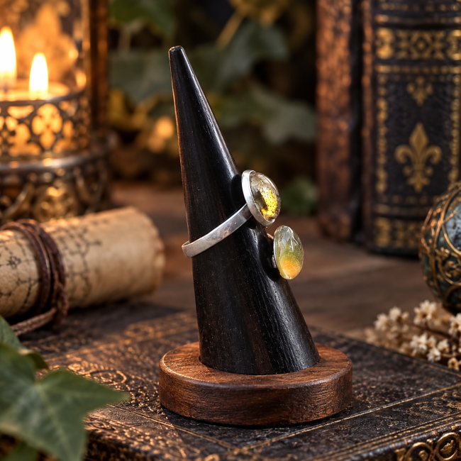 Vue de profil de la bague L’Œil du Dragon Endormi, révélant la finesse de sa structure et la disposition originale de ses deux cabochons dans un esprit médiéval fantastique.