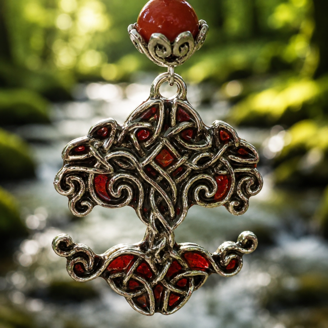 Zoom sur le pendentif arbre de vie en nœuds celtiques, sublimé par un émaillage artisanal rouge intense évoquant les frondaisons sacrées du Valhalla. Un bijou nordique raffiné aux finitions soignées.