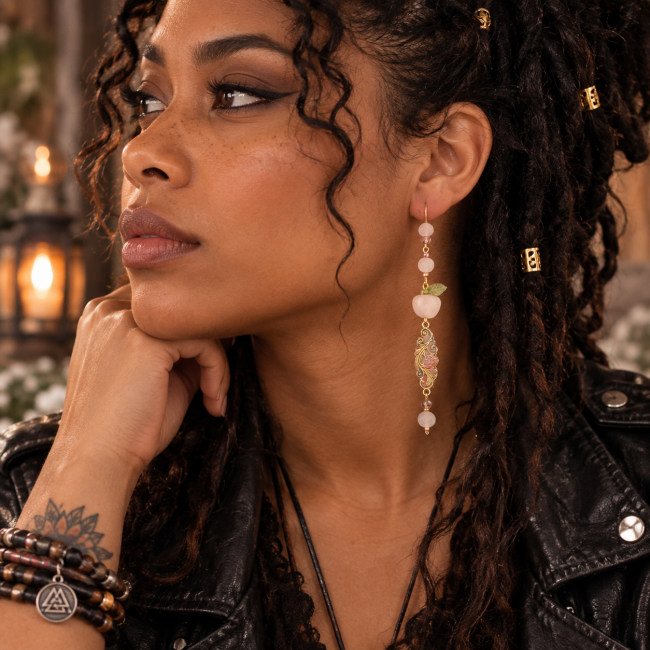 Boucle d’oreille Le Fruit d’Éternité – Style rock & mythologie nordique Deuxième boucle d’oreille Le Fruit d’Éternité portée par une femme au style rock, avec pomme rose, quartz rose et émail artisanal