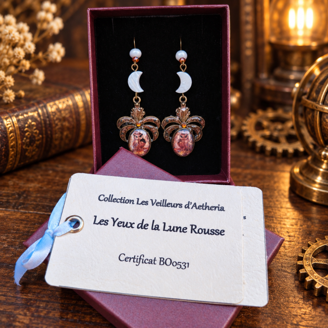 Les Yeux de la Lune Rousse dans son écrin – BO0531 Les Yeux de la Lune Rousse présentées dans leur écrin, accompagnées de leur certificat d’identification, dans une ambiance steampunk élégante et chaleureuse.