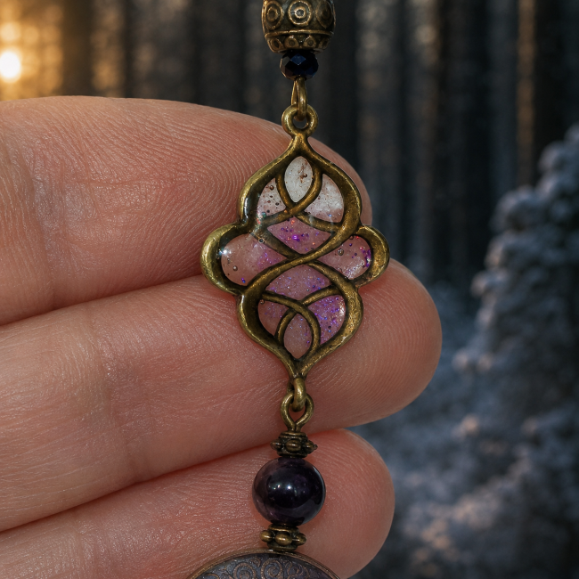 Zoom sur l’émaillage translucide violet et les motifs celtiques des boucles d’oreilles Nuit des Runes. Atmosphère hivernale nordique douce et mystérieuse.