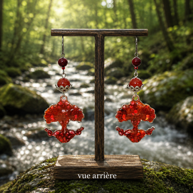 Vue arrière des boucles d'oreilles Les Frondaisons du Valhalla. L'émaillage artisanal translucide rouge révèle toute sa profondeur et sa luminosité, tandis que les perles de cornaline complètent harmonieusement cette création nordique.