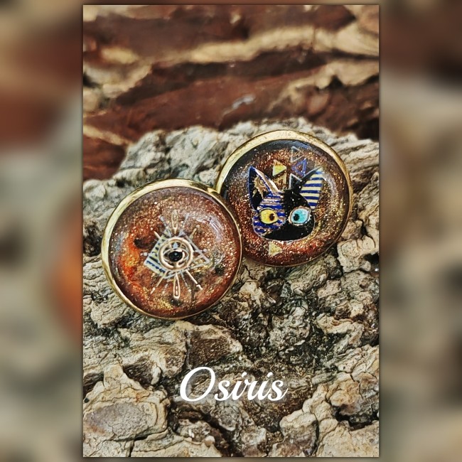 Gros plan boucles d’oreilles Osiris – Bijou artisanal mordoré | Les Fantaisies d'A Gros plan sur les clous d’oreilles Osiris artisanaux en émail mordoré avec œil rayonnant et chat égyptien
