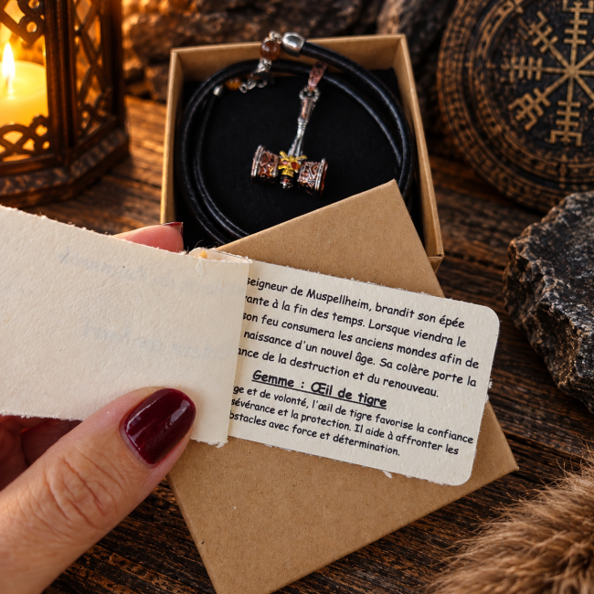 Carte accompagnant le collier La Colère de Surtr présentant sa légende ainsi que les traditions associées à l’œil de tigre, pierre naturelle utilisée pour cette création.