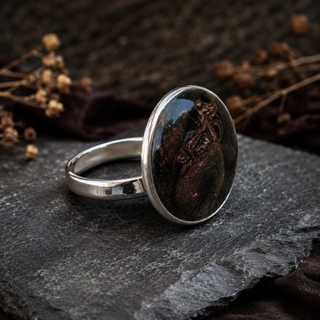 Vue de profil de la bague Le Gouffre du Drac montrant son système de réglage en acier inoxydable et son grand cabochon dragon.
