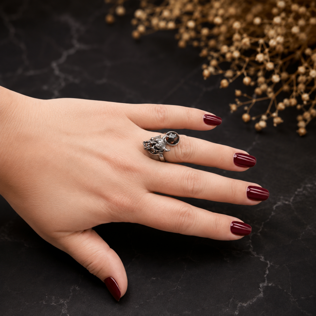 La Treizième Heure portée à la main, une bague gothique artisanale à double cabochon, associant acier inoxydable argenté, rouge et noir, dans un style sombre et contemporain.